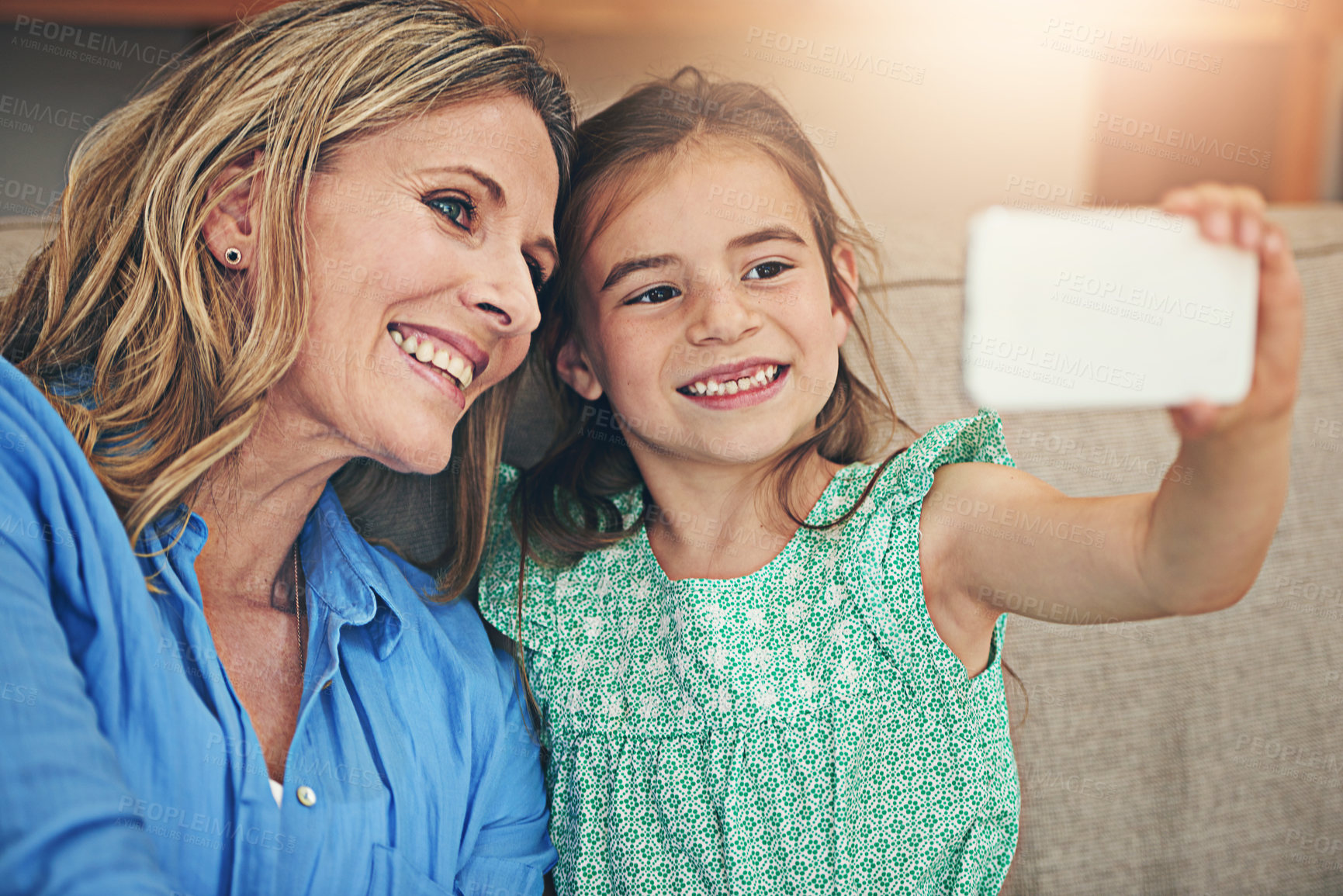 Buy stock photo Happy mom, daughter and relax with selfie on sofa for picture, memory or bonding together at home. Mother, child or kid with smile for photography, capture or moment on living room couch at house