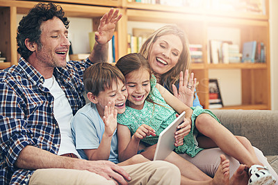 Buy stock photo Shot of a happy family making a video call on their digital tablet together at home