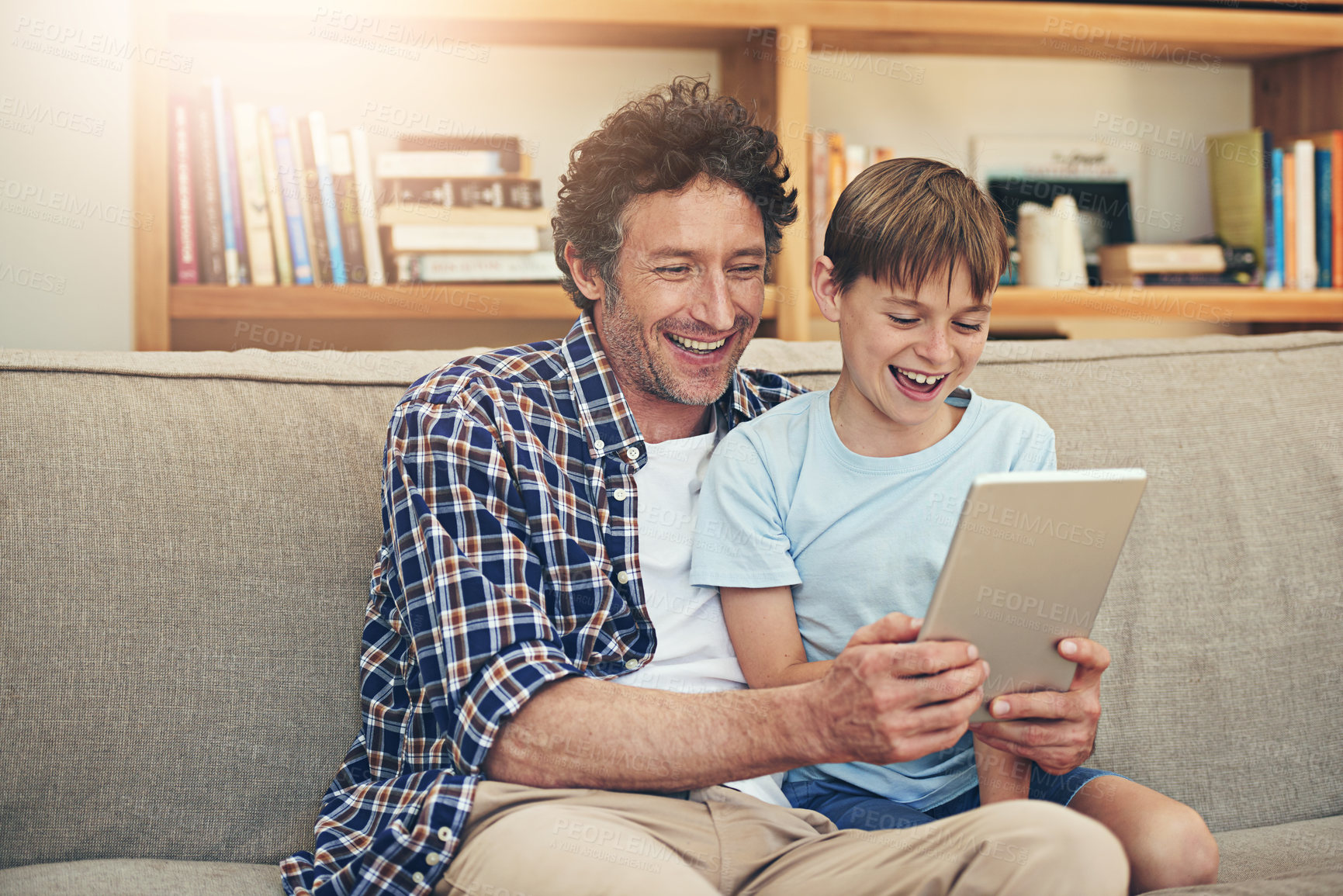 Buy stock photo Laugh, tablet and father with child in home for watching movies, cartoons and online entertainment. Family, love and dad with son on digital tech for internet, video call and relax on weekend on sofa