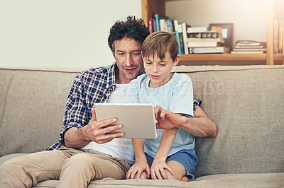 Buy stock photo Shot of a father and his son using a digital tablet together at home