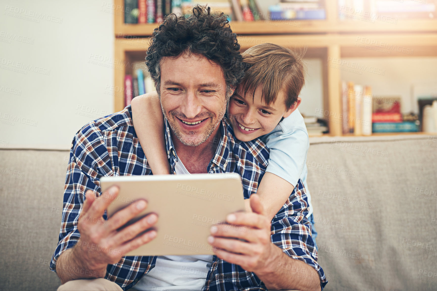 Buy stock photo Happy, tablet and child hug father in home for watching movies, cartoons and online entertainment. Family, love and dad with son on digital tech for internet, video call and relax on weekend on sofa