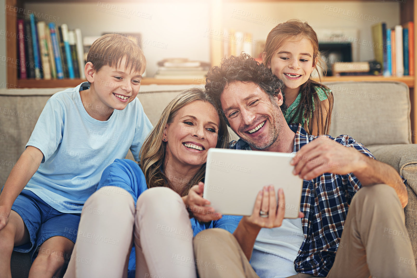Buy stock photo Happy family, relax and watching movie with tablet for online entertainment or streaming service at home. Mom, dad or children with smile on technology for show or series on living room sofa at house