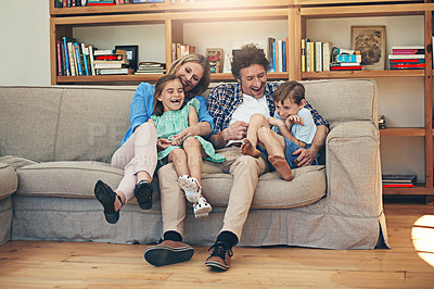 Buy stock photo Family, laughing and parents with children, couch and goofy for joke by dad, funny and comedy in house. Home, woman and man with kids, together and bonding for break in apartment, relax and love