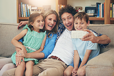 Buy stock photo Family, selfie and parents with children, couch and laughing for joke by dad, funny face and comedy in house. Home, woman and man with kids, together and bonding with photography for memory in phone
