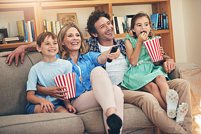 Buy stock photo Shot of a happy family watching movies on the sofa at home