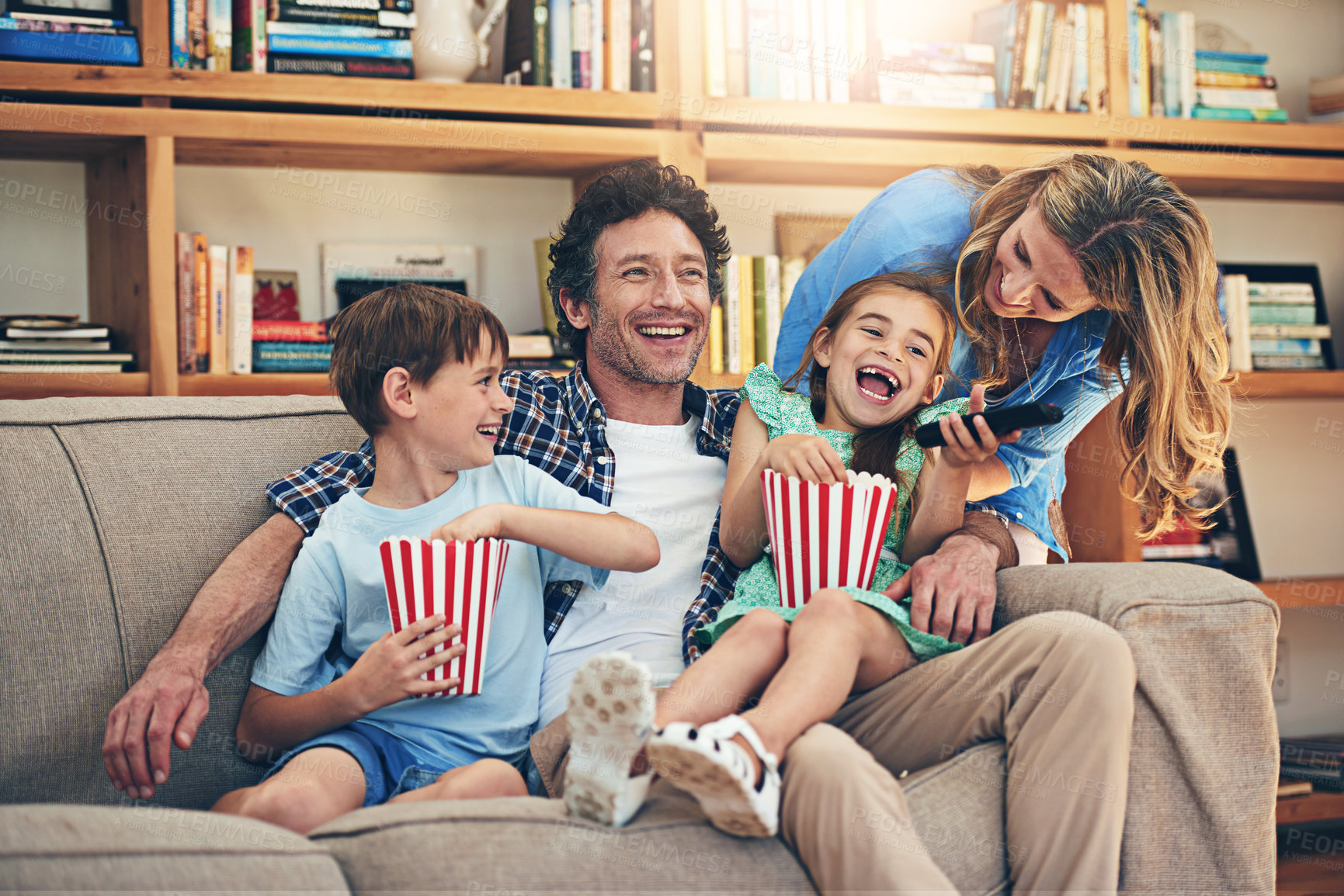 Buy stock photo Happy family, watching tv and laughing with popcorn for funny movie, weekend or holiday on living room sofa at home. Mom, dad and young children with smile for comedy or streaming service at house