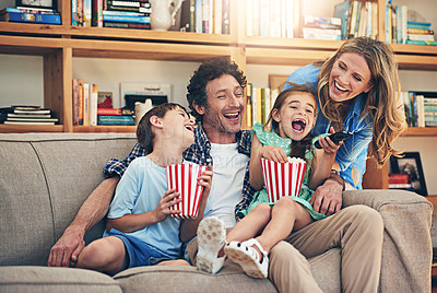 Buy stock photo Shot of a happy family watching movies on the sofa at home