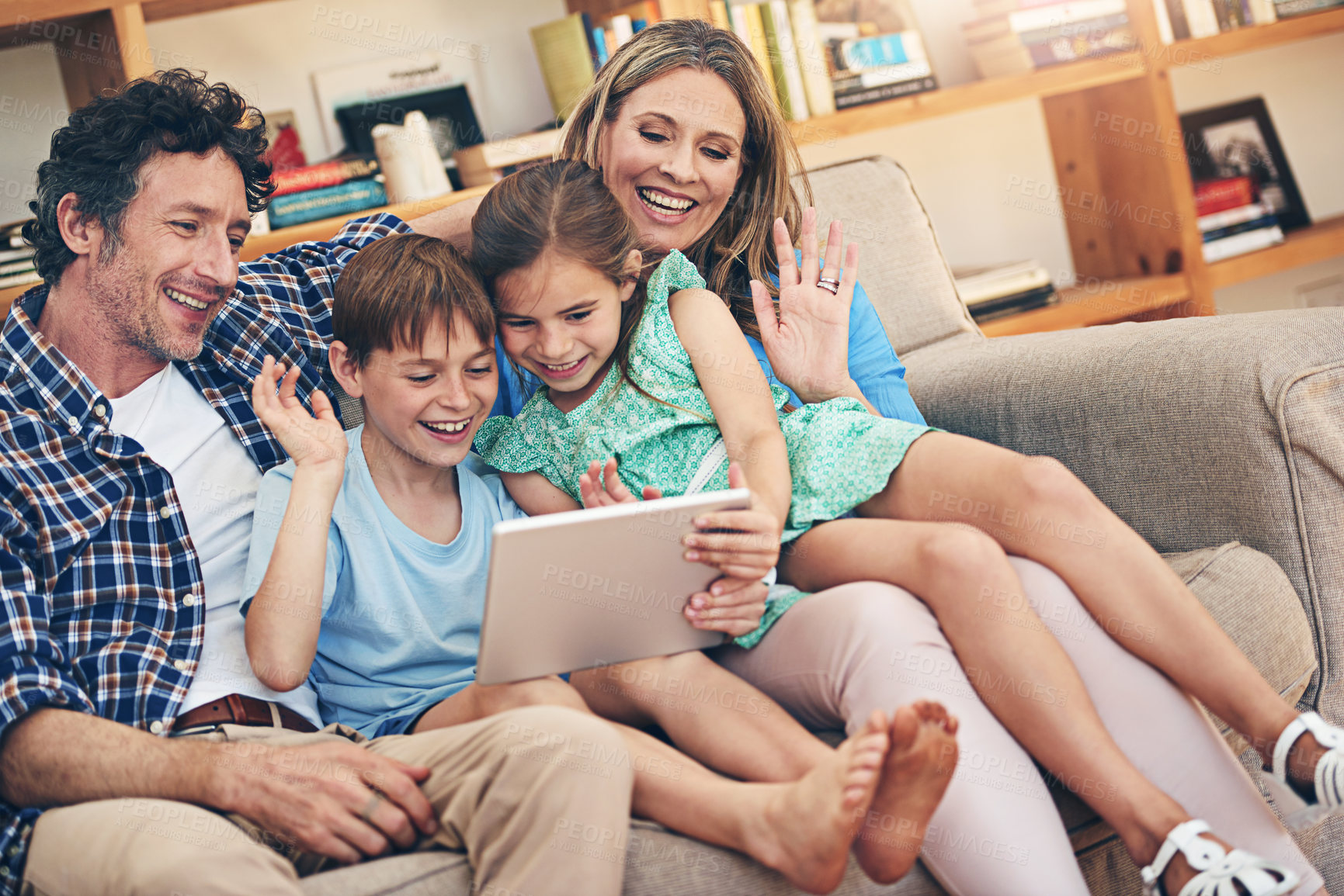 Buy stock photo Happy family, video call and wave with tablet on sofa for communication or conversation together at home. Mom, dad and young children with smile on technology for virtual discussion in living room
