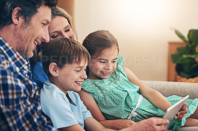 Buy stock photo Shot of a happy family using a digital tablet together at home