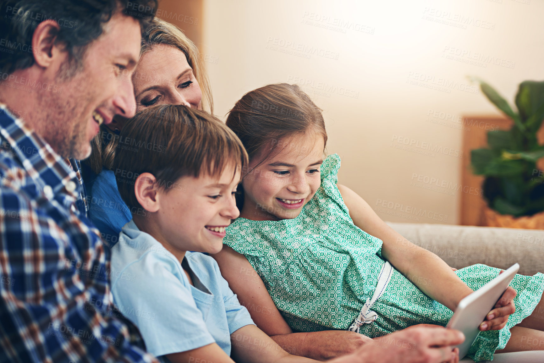 Buy stock photo Happy family, relax and watching with tablet for streaming service or entertainment at home. Mom, dad or young children with smile on technology for movie, show or series on living room sofa at house