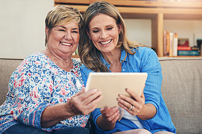 Buy stock photo Shot of a mature woman and her elderly mother using a digital tablet together at home