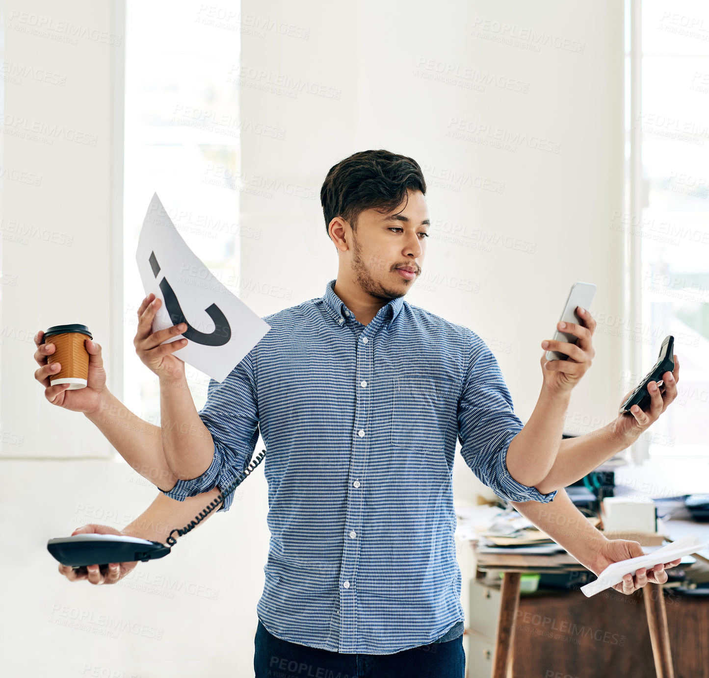 Buy stock photo Shot of a young entrepreneur multitasking at work with multiple arms