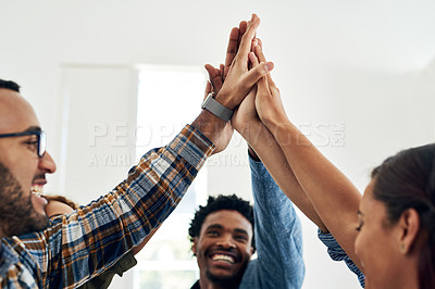 Buy stock photo Shot of a group of colleagues giving each other a high five in a modern office