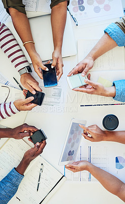 Buy stock photo Cropped shot of a group of colleagues using smart devices during a meeting at work