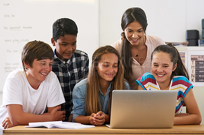 Buy stock photo Shot of a group of schoolchildren using a laptop in class with their teacher