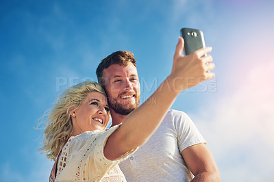 Buy stock photo Relax, smile and couple with selfie by blue sky for adventure, online post and memory of vacation. Low angle, man and woman with digital picture for social media, holiday update and travel in nature