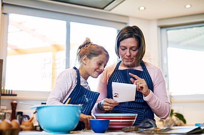 Buy stock photo Shot of a mother and her little daughter baking together at home