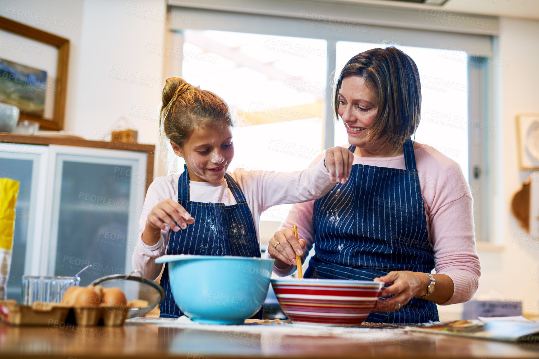 Buy stock photo Shot of a mother and her little daughter baking together at home