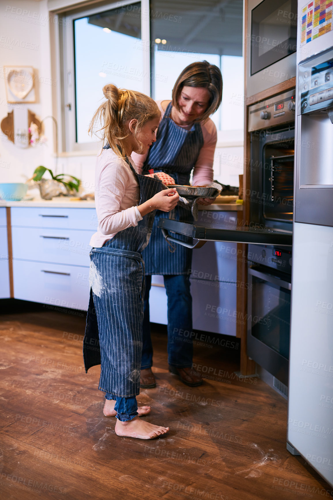 Buy stock photo Mother, girl and baking in kitchen with oven for handmade pie and bonding while learning, help and together. Mom, daughter and home for teaching skills, growth development and love for cooking.