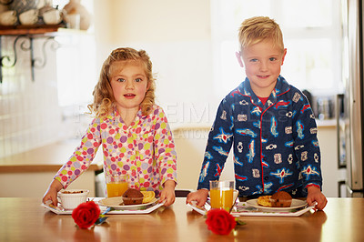 Buy stock photo Portrait of two adorable little siblings preparing breakfast on serving trays at home