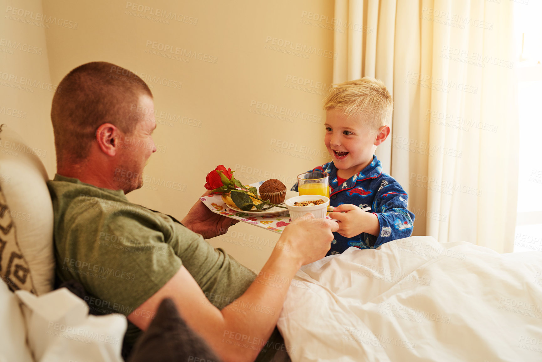 Buy stock photo Cropped shot of a little boy serving breakfast in bed to his father at home
