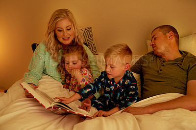 Buy stock photo Cropped shot of a family reading a bedtime story together at home