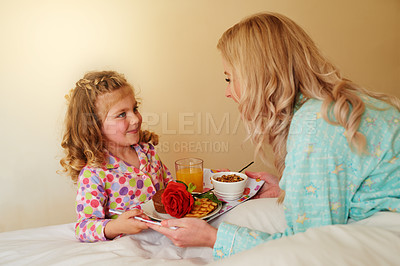 Buy stock photo Cropped shot of a little girl serving breakfast in bed to her mother at home