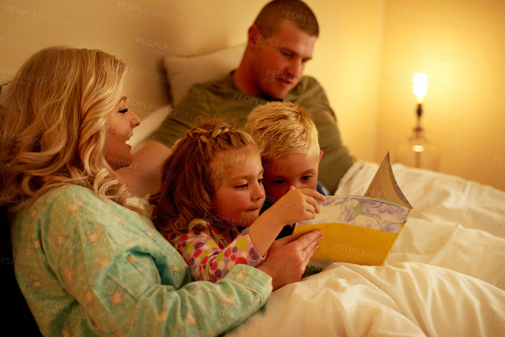 Buy stock photo Cropped shot of a family reading a bedtime story together at home