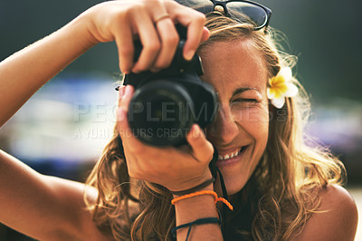 Buy stock photo Portrait of a young woman taking photos with her camera at the beach