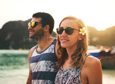 Buy stock photo Cropped shot of a young couple enjoying a day at the beach together