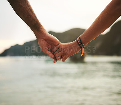 Buy stock photo Closeup shot of a young couple holding hands at the beach