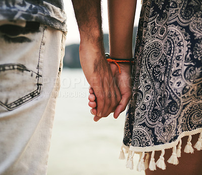 Buy stock photo Closeup shot of a young couple holding hands at the beach