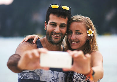 Buy stock photo Cropped shot of a young couple taking a selfie at the beach