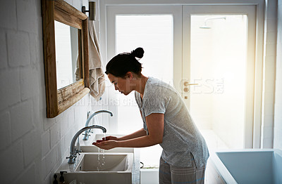 Buy stock photo Cropped shot of an attractive young woman washing in the bathroom