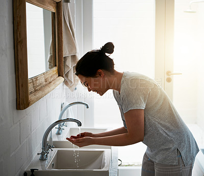 Buy stock photo Cropped shot of an attractive young woman washing in the bathroom