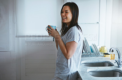 Buy stock photo Cropped shot of an attractive young woman enjoying a coffee while standing in the kitchen
