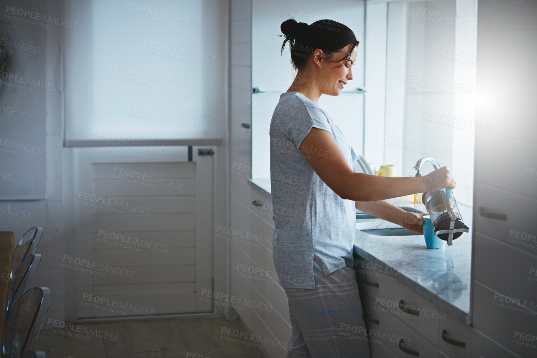 Buy stock photo Cropped shot of an attractive young woman preparing a pot of coffee in the kitchen