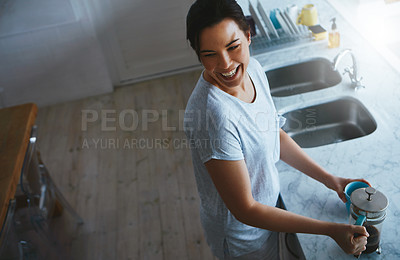 Buy stock photo High angle shot of an attractive young woman preparing a pot of coffee in the kitchen