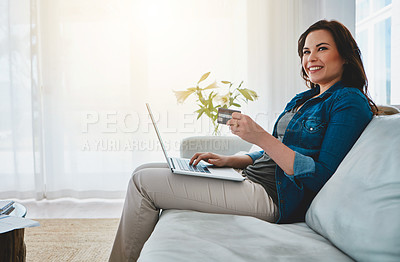 Buy stock photo Cropped shot of an attractive young woman shopping online using her laptop