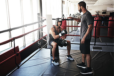 Buy stock photo Shot of a man training in the boxing ring with a coach