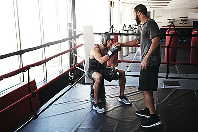 Buy stock photo Shot of a man training in the boxing ring with a coach