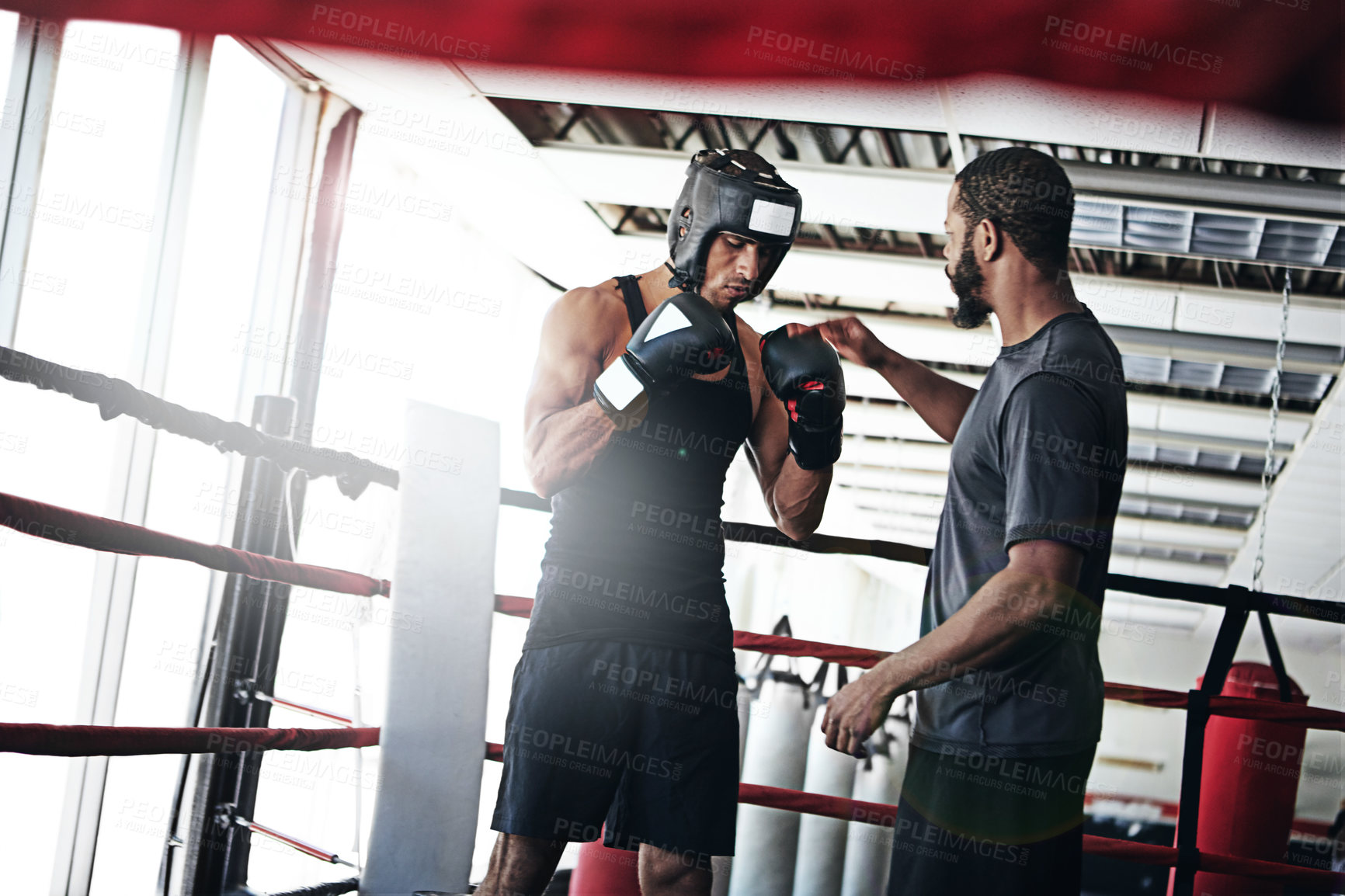 Buy stock photo Shot of a man training in the boxing ring with a coach