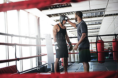 Buy stock photo Shot of a man training in the boxing ring with a coach