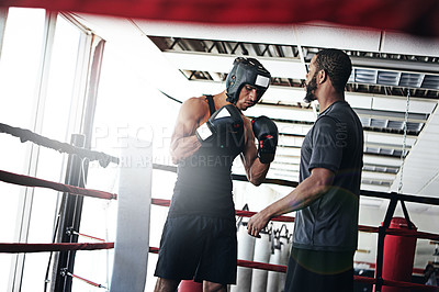 Buy stock photo Shot of a man training in the boxing ring with a coach