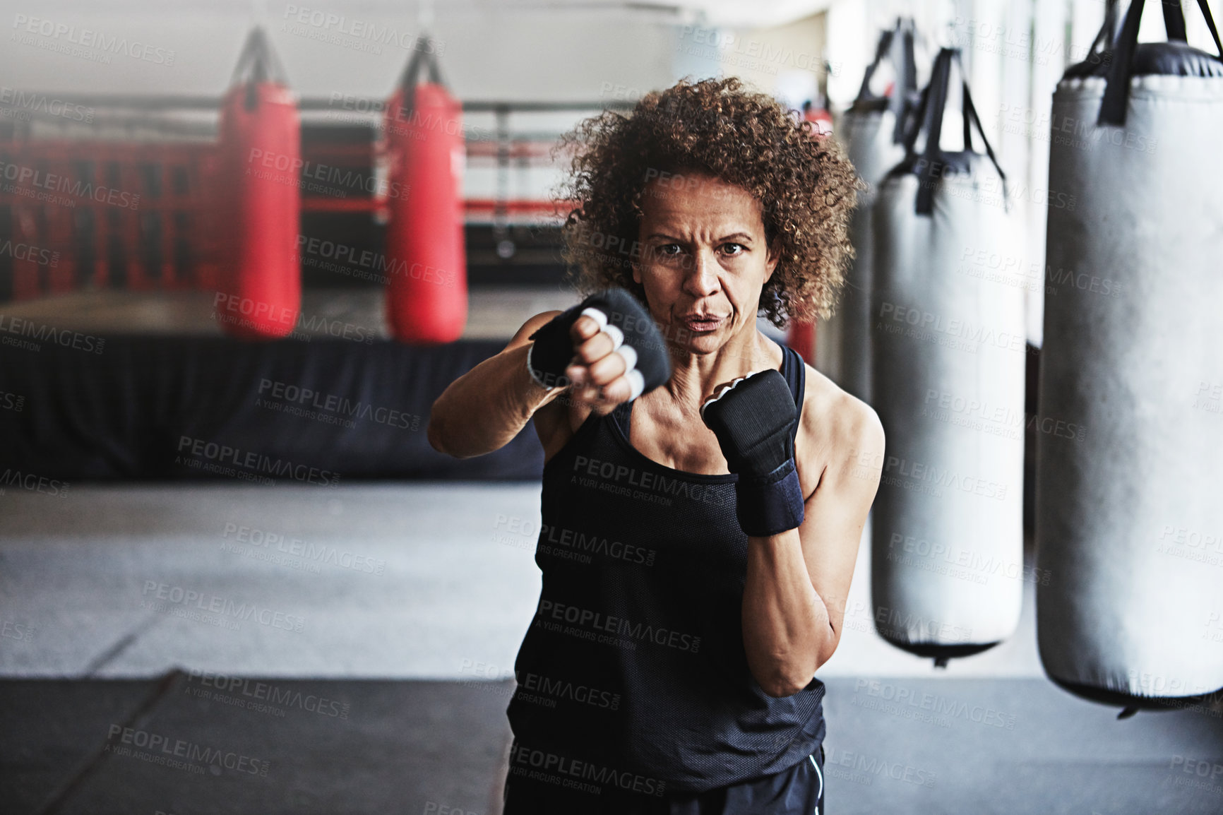 Buy stock photo Fitness, punching and mature woman in gym for exercise, boxing challenge or competition training. Power, muscle and champion boxer at workout with confidence, fight and energy in MMA sports club.