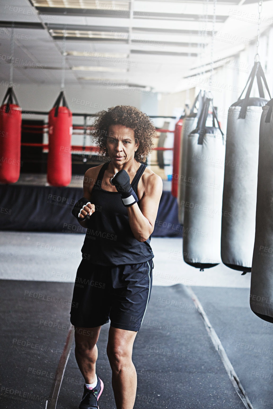 Buy stock photo Boxing, punching bag and mature woman in gym for exercise, MMA challenge or competition training. Power, muscle fitness and champion boxer at workout with confidence, fight and energy in sports club.