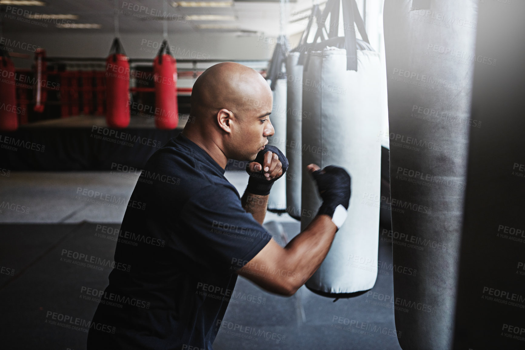 Buy stock photo Fitness, punching bag and man in boxing gym for MMA, challenge or competition training. Power, muscle and serious champion boxer at workout with confidence, fight and energy in sports exercise club.