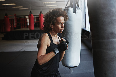 Buy stock photo Gym, punching bag and mature woman in boxing for workout, challenge or competition training. Power, muscle and strong champion boxer in exercise with confidence, fight and energy in MMA sports club.