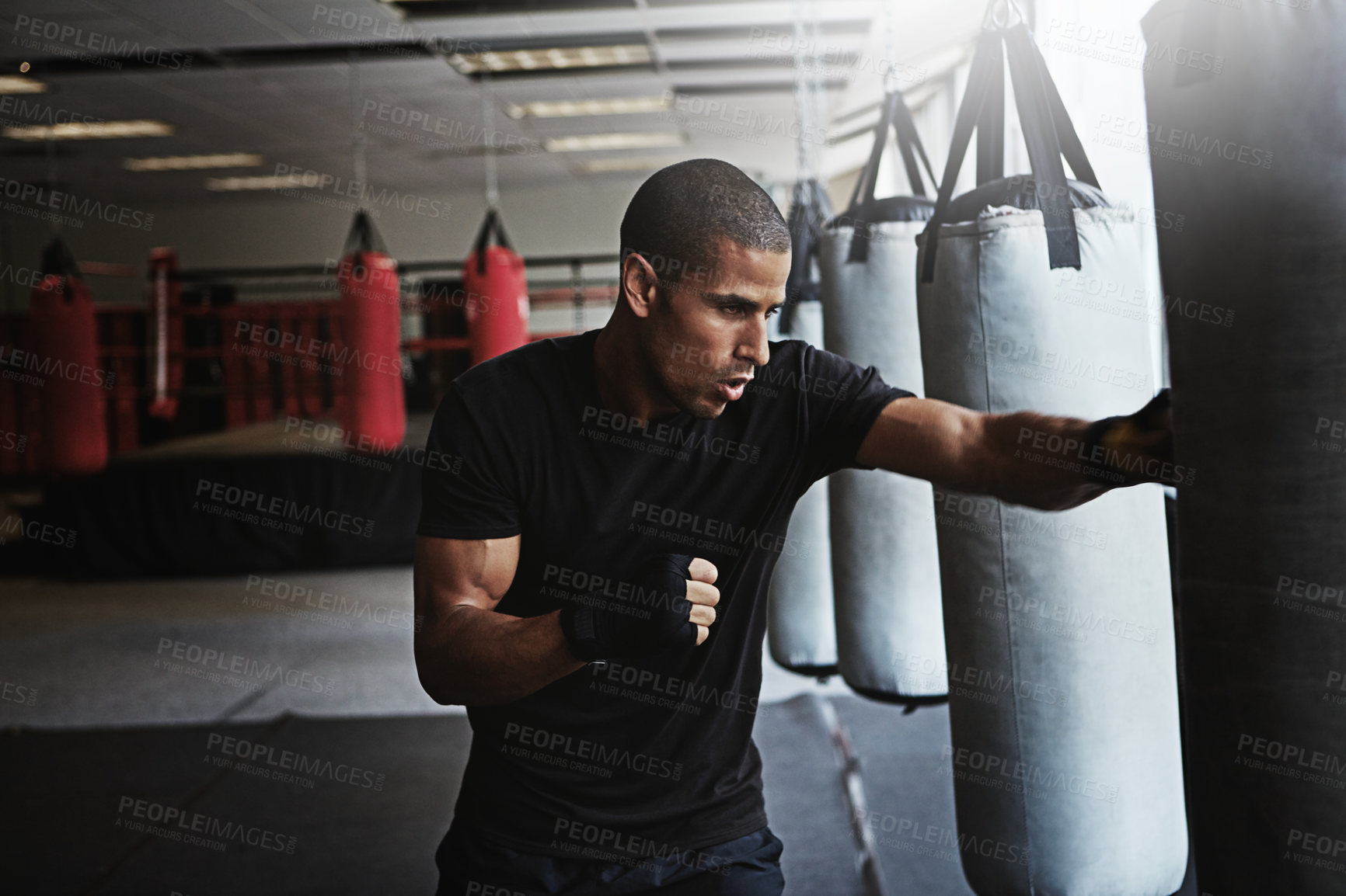 Buy stock photo Hit, punching bag and man in boxing gym for workout, challenge or competition training. Power, muscle and strong champion boxer in exercise with confidence, fitness and energy in MMA sports club.