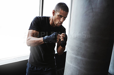 Buy stock photo Hit, punching bag and man in boxing club for workout, challenge or competition training. Power, muscle and strong champion boxer in exercise with confidence, fitness and energy in MMA sports gym.